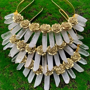 Serre-tête artisanal en cristal blanc avec fleurs dorées sur fond de mousse naturelle