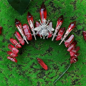 Gothic red crystal crown headband with silver bee motif on green moss background
