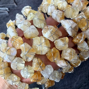 Dettaglio di pietre grezze di ametista avvolte a mano con filo metallico d'argento