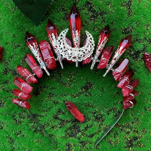 Handmade red crystal crown headband with silver crescent moon on green moss background