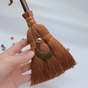 Detail of handmade witch broom pendant with bronze moon charm and crystal accents
