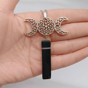 Detail der handgefertigten dreifachen Mondkette mit Silberanhänger und schwarzem Stein