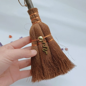 Detail of mini witch broom pendant with metal snake charm and wooden handle