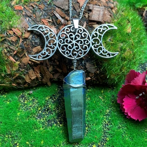 Macro view of handmade triple moon necklace with iridescent crystal and wire wrapping