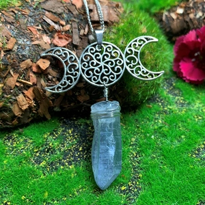 Detailed view of handmade triple moon goddess necklace with natural white crystal and mossy bark