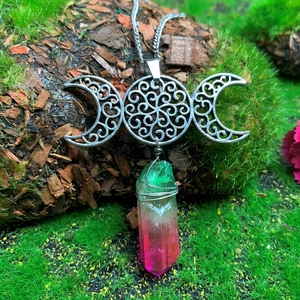Triple Moon Goddess necklace with wire-wrapped crystal on mossy wooden log