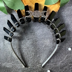 Detailed macro view of black crystal shards and triple moon motif on the gothic crown
