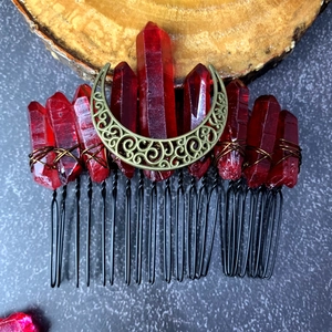 Detail of red raw crystal columns and bronze moon ornament on a handmade hair comb