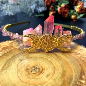 Macro view of handmade pink crystal sun goddess crown on a rustic wooden base