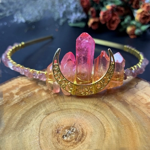 Detailed close-up of handmade pink crystal sun goddess crown with golden moon crest