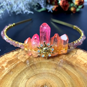 Detail of handmade quartz sun goddess crown with pink crystals and golden sun emblem