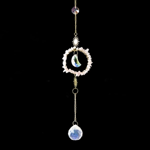 Handmade rose quartz sun catcher with crescent moon crystal and metal stars on black background