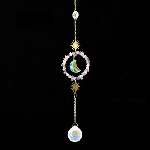 Detail of suncatcher with natural amethyst stones, crystal ball, and gold moon moon charms