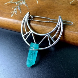 Detailed macro view of moon hair pin featuring a raw teal crystal on a silver metal frame