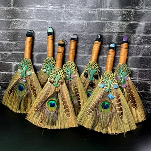 Détails de balais de sorcière avec cristaux d'améthyste et plumes de paon