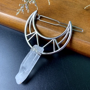 Detail view of moon hair clip with raw white crystal pillar and silver metal wire wrapping