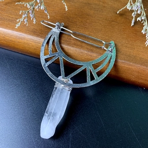 Detail view of crescent moon hair clip with natural white crystal and silver metal wire wrapping