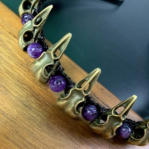 Detail of gothic crow skulls and purple amethyst beads on a handmade hairband headband