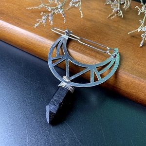 Detail of silver moon hair clip with natural black crystal and wire-wrapped craft