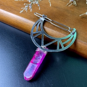 Macro detail of crescent moon hair clip with purple crystal pendant and wire wrap