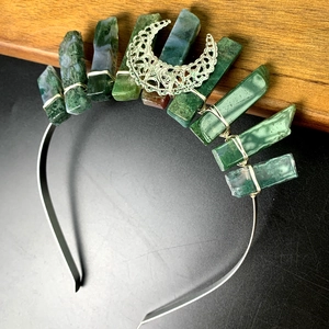 Detail of bohemian handmade headband with green raw crystals and silver crescent moon