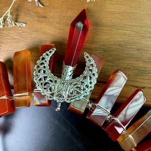 Macro detail of handmade red agate crystal crown with silver crescent moon and wire wrapping