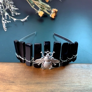 Detail of handmade crown headband featuring black crystal stones and silver bee charms