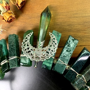 Macro view of crystal crown showing green raw stones and silver wire wrap detail