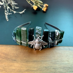 Close-up of raw green crystal stones and silver bee detail on the handmade crown