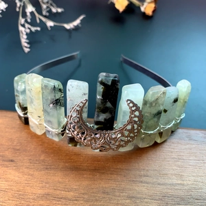 Close-up of handmade green crystal crown with a moon pendant and wire wrapping details