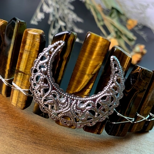 Close-up of handmade tiger eye stones and silver moon detail on bohemian crown headband