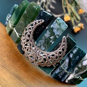 Detailed close-up of handmade crescent moon headband with natural green stone textures