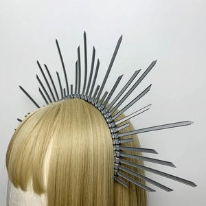 Detailed side profile of silver halo headband with sunburst zip tie spikes on gold hair