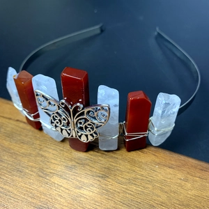 Detail of red and white raw crystals hand-wrapped with silver wire and a metal butterfly