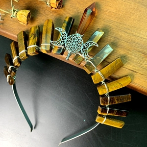 Macro detail of natural tiger eye stones and silver moon on handmade crystal crown
