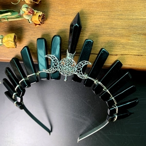 Macro shot of gothic crown with black obsidian crystals and silver moon sun totem