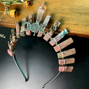 Macro detail of natural pink quartz crown with wire-wrapped Triple Moon Goddess symbol