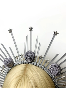 Détail de la couronne halo argentée avec étoiles métalliques et roses en satin sur serre-tête