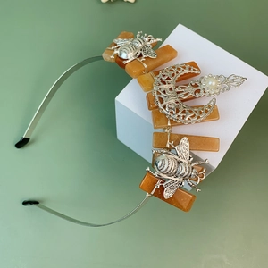 Detail view of handmade moon and honeybee elements on a vintage crystal crown headband