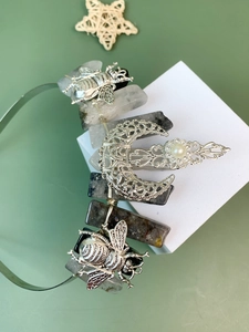 Detail of silver crown headband with natural crystals, metal bees and moon charms