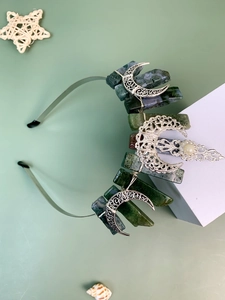 Detail of bohemian crown headband with green crystals and silver moon accents