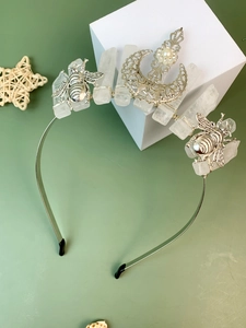 Detail of silver crown headband featuring raw white crystals, moon, bee, and pearl