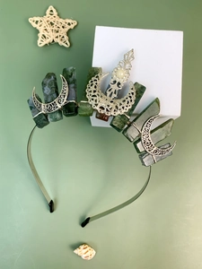 Detail view of raw green crystal crown with silver crescent moon and filigree flower
