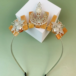 Silver bee tiara with crescent moon, orange crystals and pearls on minimalist white base