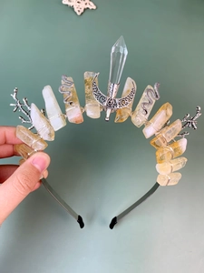 Macro shot of handmade wire-wrapped silver crown with yellow crystals and moon charms