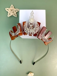 Detail view of handcrafted moon charms and red crystals on the beaded metal headband