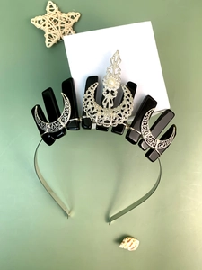 Close-up of gothic tiara with black stones, silver crescent moons, and a center pearl