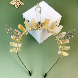 Handmade crown headband with yellow crystals and silver wire on a geometric stand