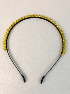 Close-up of yellow crystal beads hand-wrapped on a slim black metal bridal headband