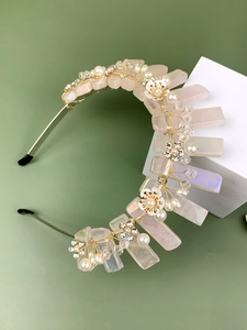 Détail d'un serre-tête de mariée fait main avec cristaux roses, perles et motifs fleurs dorés